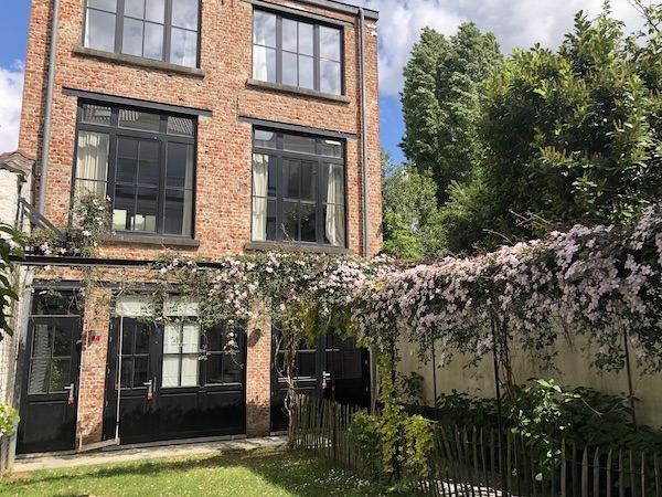 un jardin fleuri qui mène à une maison à Etterbeek