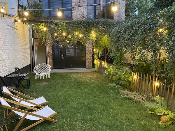 Un jardin pour événement avec des chaises longues, des illuminations
