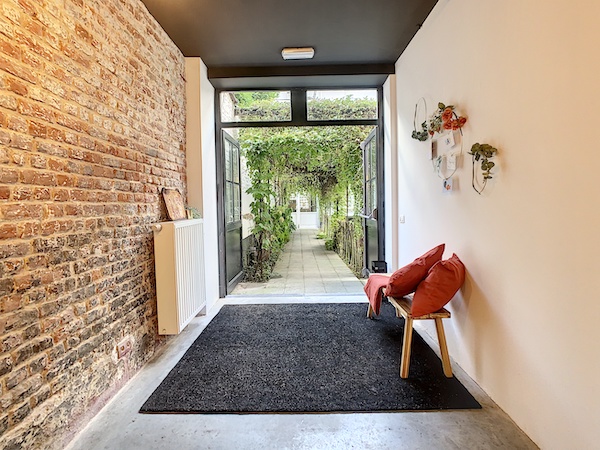 Le hall d'entrée d'une salle à louer à Etterbeek avec un banc