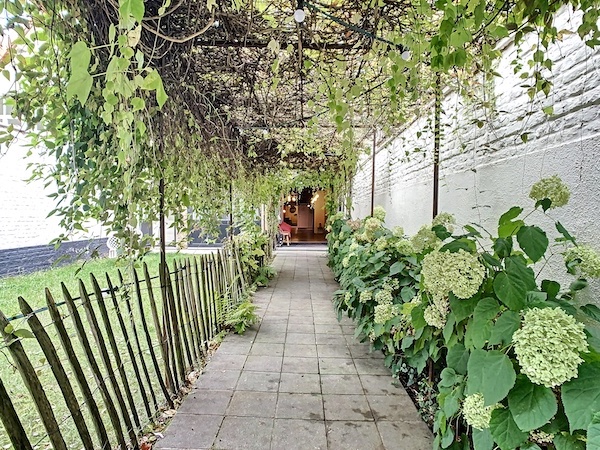 Une entrée pavée avec un jardin à Bruxelles dans une salle en location